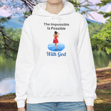 Gildan unisex hoodie with “Impossible Woman” design featuring a woman walking on water and uplifting message, Christian apparel made from soft cotton-poly blend, ideal for cold weather and faith-forward style, woman in white hoodie